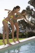 Two teenage girls having fun by a pool
