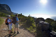 Photo: Mature couple hiking on mountain trail, looking at Atlantic Ocean horizon in bright sunlight, side view (lens flare) Mature couple hiking on mountain trail, looking at Atlantic Ocean horizon in bright sunlight, side view (lens flare)