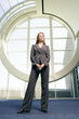 Photo: Confident businesswoman, with ginger hair, wearing grey suit, smiling, front view, portrait (surface level) Confident businesswoman, with ginger hair, wearing grey suit, smiling, front view, portrait (surface level)