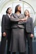 Three confident businesswomen, in grey suits, standing in lobby, front view, portrait, low angle view
