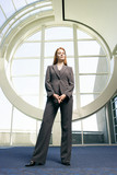Photo: Confident businesswoman, with ginger hair, wearing grey suit, smiling, front view, portrait (surface level) Confident businesswoman, with ginger hair, wearing grey suit, smiling, front view, portrait (surface level)