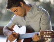 A young man playing a guitar