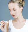 A young woman looking at a pregnancy test