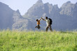 Photo: Father and son (8-10) hiking on mountain trail, boy jumping in air, giving man high five, profile Father and son (8-10) hiking on mountain trail, boy jumping in air, giving man high five, profile
