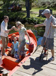 Photo: Multi-generational family boarding motorboat on lake jetty, man offering wife helping hand, senior man with fishing rod Multi-generational family boarding motorboat on lake jetty, man offering wife helping hand, senior man with fishing rod