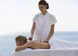 A young woman receiving a hot stone holistic treatment