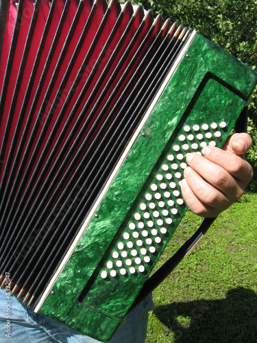 Photo: Playing the accordion in the garden, details close up Playing the accordion in the garden, details close up