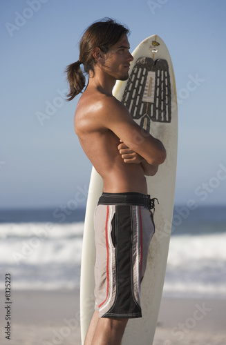 Foto: A surfer standing on a beach A surfer standing on a beach