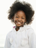 Photo: Girl (7-9), with afro, wearing white top, smiling, close-up, front view, portrait Girl (7-9), with afro, wearing white top, smiling, close-up, front view, portrait