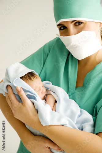Photo: A medical practitioner holding a newborn baby A medical practitioner holding a newborn baby