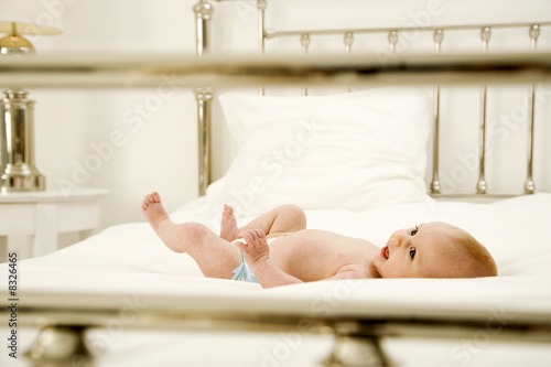 Photo: A baby laying on a bed A baby laying on a bed