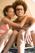 Photo: Young couple sitting inside tent, woman embracing boyfriend, man wearing sunglasses, smiling, portrait Young couple sitting inside tent, woman embracing boyfriend, man wearing sunglasses, smiling, portrait