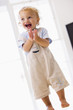 Young boy standing applauding and smiling