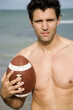A young man with a ball on the beach
