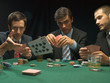 Men throwing playing cards at poker game