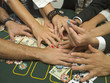 Detail of arms reaching for money at poker game