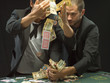 Men grabbing money at poker game