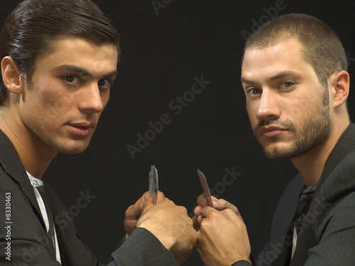 Photo: Men facing off with playing cards Men facing off with playing cards