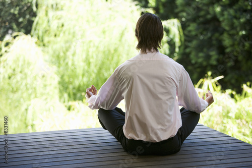 Foto: A businessman meditating in a garden A businessman meditating in a garden