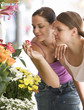 Two young women looking at a flower stall