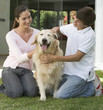 A brother and sister with their dog in the garden