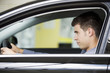 A young man admiring a new car