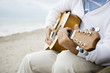 A senior man playing a guitar