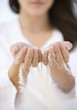 A woman with sand running through her hands