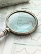 View of graph in newspaper through magnifying glass