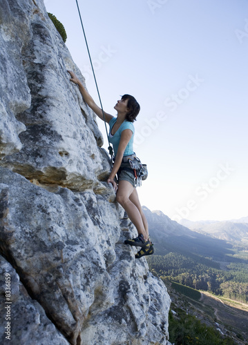 Photo: A climber climbing a rock face A climber climbing a rock face