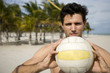 A young man playing beach volleyball
