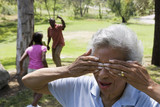 Photo: Children (6-10) playing hide and seek with grandparents in park, senior woman covering eyes Children (6-10) playing hide and seek with grandparents in park, senior woman covering eyes