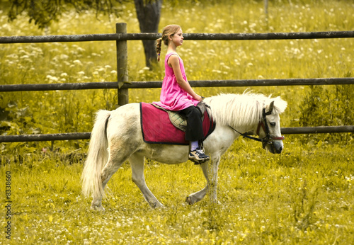 Photo: Young girl riding pony Young girl riding pony
