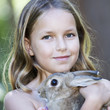 A young girl holding a pet rabbit, close-up