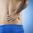 A young man holding his back