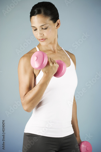 Photo: A young woman lifting weights A young woman lifting weights