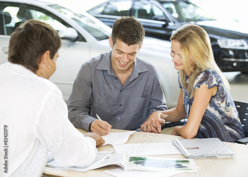 Foto: A young couple buying a new car A young couple buying a new car