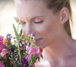 A young woman sniffing a bouquet of flowers, close-up