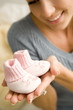 A mother holding a pair of baby bootees