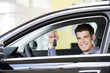 A young man with keys to a new car