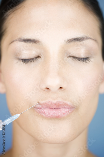 Foto: A young woman having a collagen injection A young woman having a collagen injection