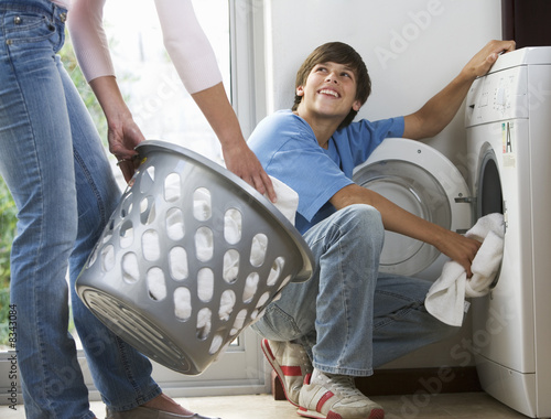 Photo: A mother and son loading the washing machine A mother and son loading the washing machine