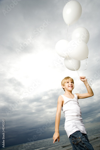 Photo: A young boy with a bunch of balloons A young boy with a bunch of balloons