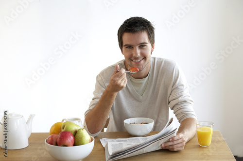 Photo: Young man having breakfast Young man having breakfast