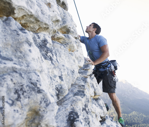 Photo: A climber climbing a rock face A climber climbing a rock face