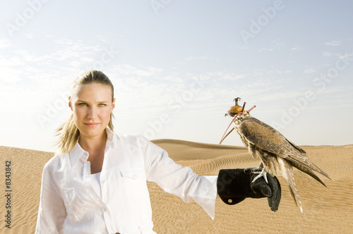 Photo: A woman standing in the desert with a hawk A woman standing in the desert with a hawk
