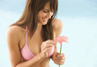 A young woman in a bikini holding a flower