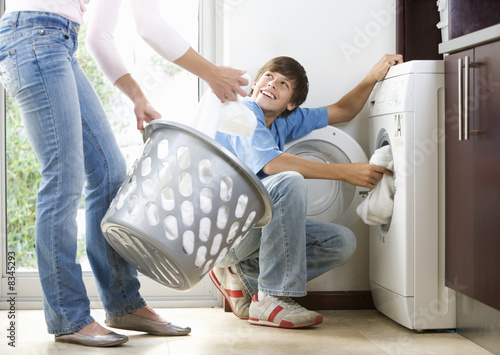 Photo: A mother and son loading the washing machine A mother and son loading the washing machine
