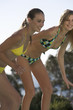 Two teenage girls having fun by a pool