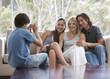 Foto: A young boy taking a photo of his family sitting on a sofa A young boy taking a photo of his family sitting on a sofa